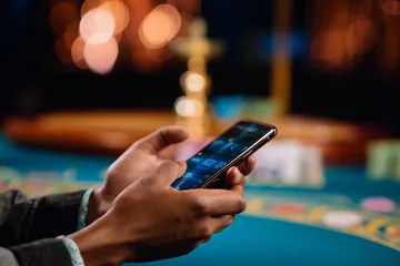 A player using their smartphone during a festive local event, representing BEFFURY’s fully mobile-friendly casino.